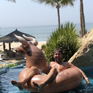 a man in a pool with a giant elephant