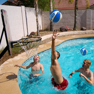 a group of people playing with a ball in a pool