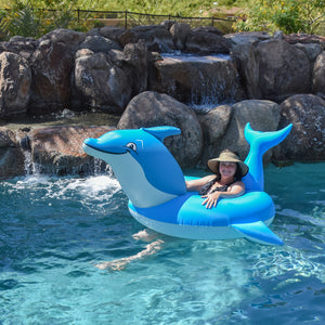 a woman in a pool with a dolphin float
