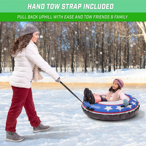 woman pulling blue white star snow tube with a child on top